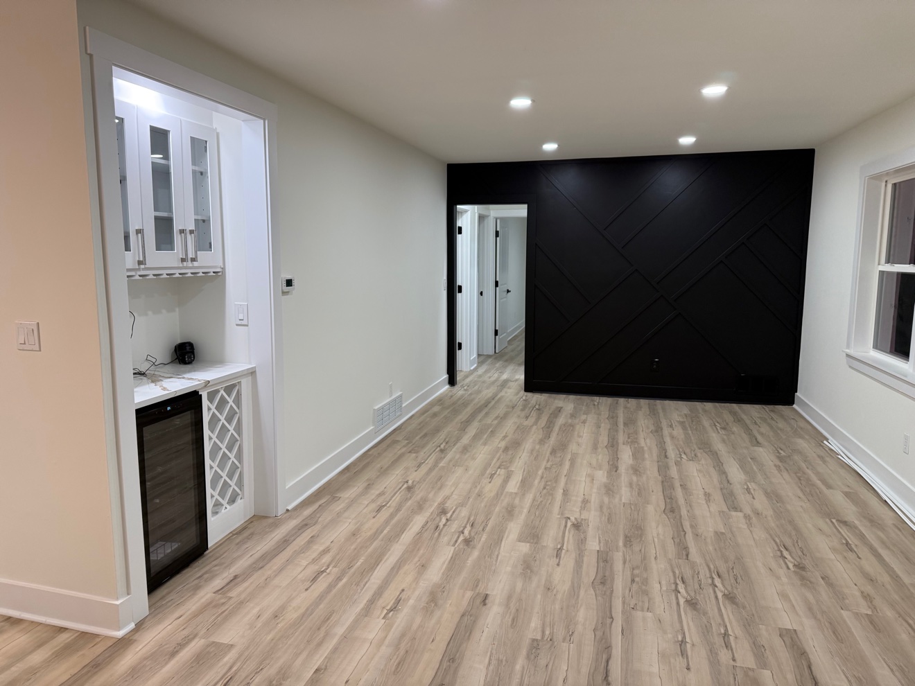 Living room with a black geometric accent wall and a built-in wine bar